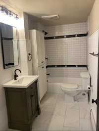 a bathroom with black and white tile and a toilet