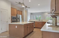 a kitchen with wooden cabinets and a ceiling fan