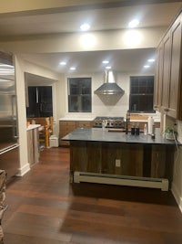 a kitchen with wood floors and stainless steel appliances