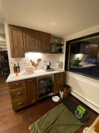 a small kitchen with a dog bed and a window