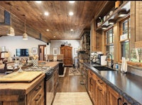 a large kitchen with wood cabinets and a wood stove