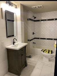a bathroom with black and white tile and a toilet