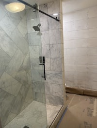 a bathroom with a glass shower door under construction
