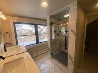 a bathroom with two sinks and a shower