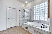 a white bathroom with a glass shower door