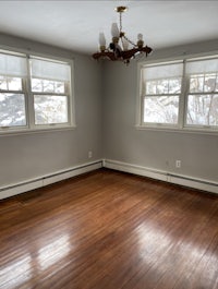 an empty room with hardwood floors and windows
