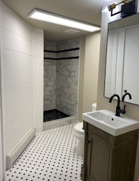 a bathroom with a black and white tiled floor