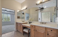 a bathroom with two sinks and a ceiling fan