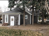 a gray house with trees in front of it