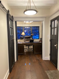 a hallway with two doors and a desk