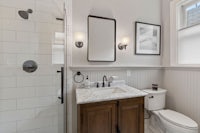 a bathroom with a toilet, sink and shower