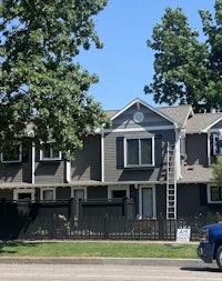 a gray house with a car parked in front of it