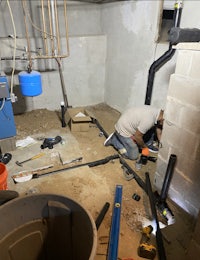 a man is working on a pipe in a basement