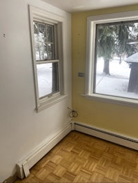 an empty room with wooden floors and a window