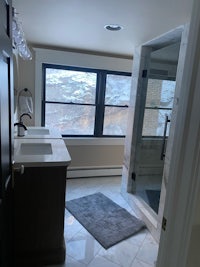 a bathroom with a large window overlooking the mountains