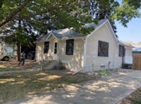 a small house with a tree in front of it