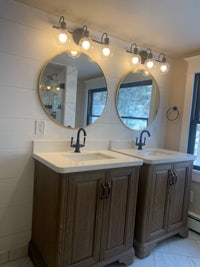 a bathroom with two sinks and two mirrors