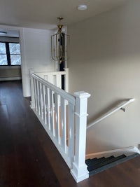 a white stair railing in a house with hardwood floors
