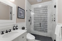 a white and black bathroom with a shower stall